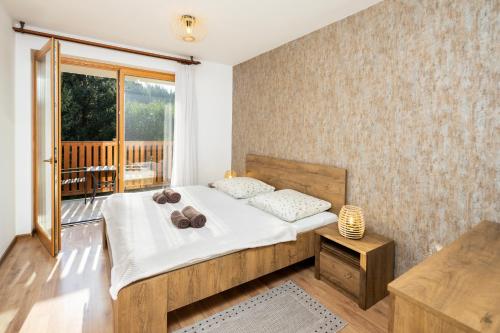 Un dormitorio con una cama y un balcón. en Apartmán SOSNA, en Dolný Kubín