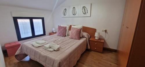 a bedroom with a bed with two towels on it at Vivienda Turistica IBAMA1 in Ciudad-Rodrigo