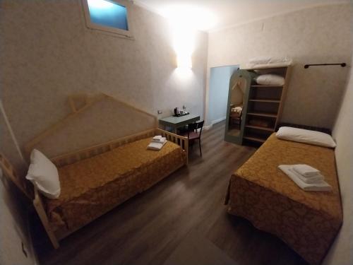 a hotel room with two beds and a mirror at Hotel Montreal in Florence
