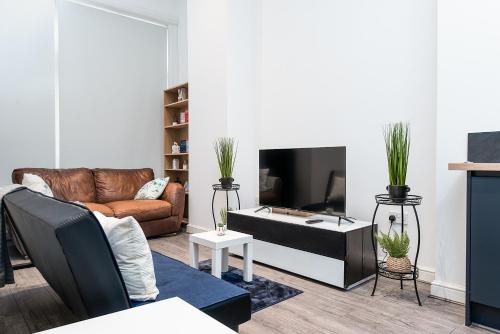 a living room with a couch and a tv at Deluxe 2 Bedroom Apartment In City Centre in Nottingham