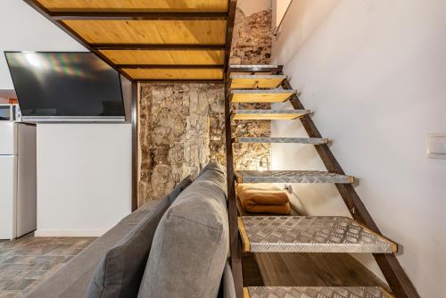 a staircase in a room with a couch and a tv at OLD TOWN EXPERIENCE CENTRAL Apartment in Tarragona