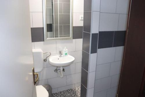 a bathroom with a sink and a mirror at Gostionica Tava in Tuzla