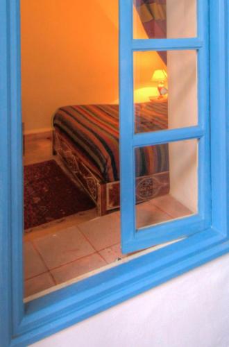 a reflection of a bed seen through a window at Les Matins Bleus in Essaouira