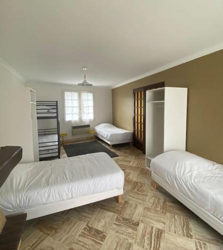 une chambre avec deux lits dans une pièce dans l'établissement La Maison de marie, à La Boissière-sur-Evre