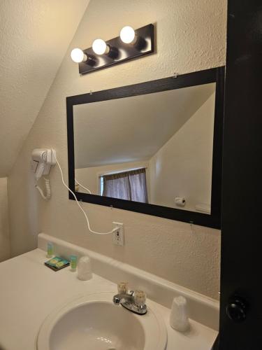 a bathroom with a sink and a large mirror at H&H Motor Lodge in Idaho Springs