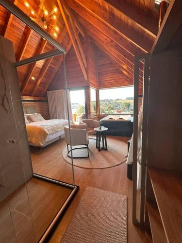 a room with a bedroom and a bed and a table at Salto Cabanas Village in São Francisco de Paula