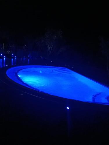 a blue swimming pool lit up at night at Maropeng Boutique Hotel in Magaliesburg