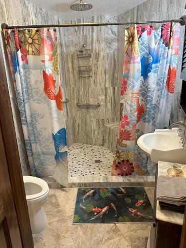 a bathroom with a shower curtain and a toilet at Hawaii Magic Skies Farmstay in Hilo