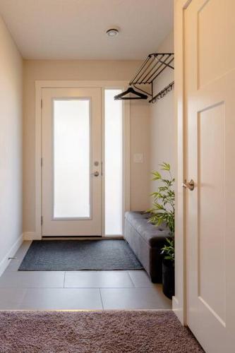 a hallway with a door with a couch and a window at Exquisite One Bedroom Apartment in NW in Calgary