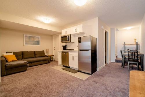 a living room with a couch and a refrigerator at Exquisite One Bedroom Apartment in NW in Calgary