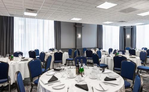 a conference room with tables and chairs with bottles at Le Nouvel Hotel in Montréal