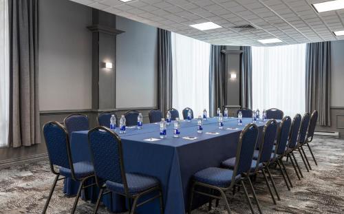 a conference room with a blue table and chairs at Le Nouvel Hotel in Montréal