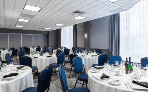 a conference room with tables and chairs and tablesktop at Le Nouvel Hotel in Montréal