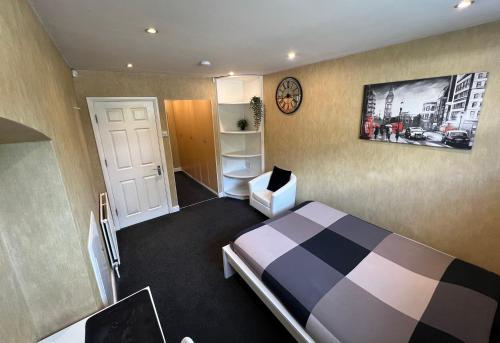 a bedroom with a bed and a clock on the wall at Beddington Park Lodge East in Wallington