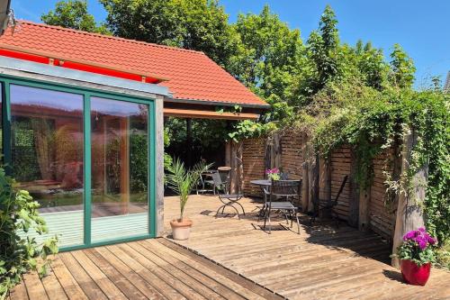 a house with a wooden deck with a conservatory at Ökologisches Hideaway mit Sauna und großem Garten in Seßlach