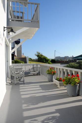 a porch with benches and flowers on a building at The Bay Lodge in Gansbaai