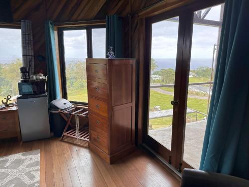 a room with a dresser and a large glass door at Hawaii Magic Skies Farmstay in Hilo