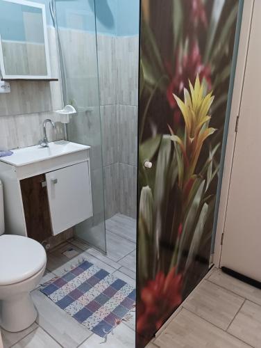 a bathroom with a shower with a toilet and a sink at Studio Dunas Porto Lagoa in Florianópolis