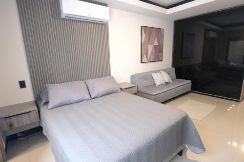 a bedroom with a white bed and a couch at Experiencia de lujo en Sky Elite in El Pary