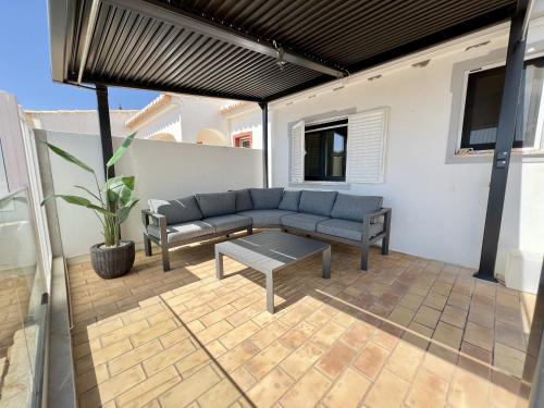 a patio with a couch and a table at Algarve Premium Villa With Pool by Homing in Santa Bárbara de Nexe