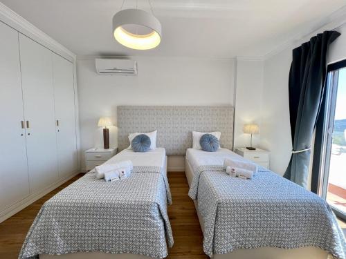 a bedroom with two beds and a window at Algarve Premium Villa With Pool by Homing in Santa Bárbara de Nexe