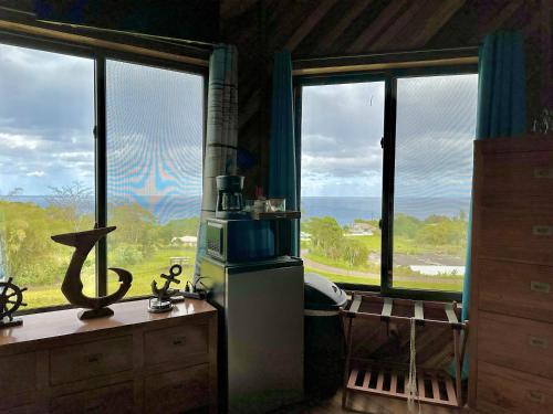 a kitchen with a view of the ocean through windows at Hawaii Magic Skies Farmstay in Hilo