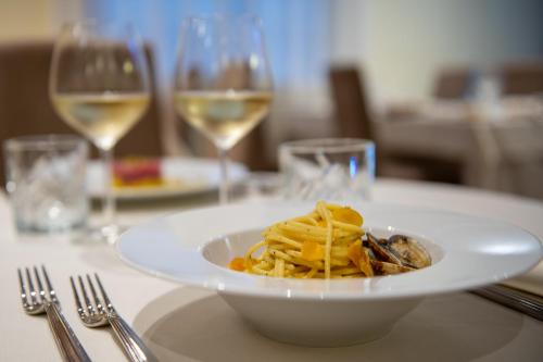 a plate of pasta on a table with wine glasses at Antica Villa Graziella Venice - Atika & Atif in Marghera