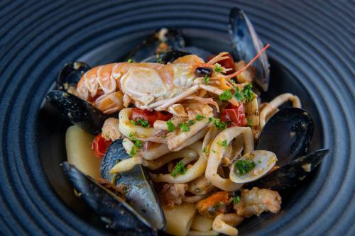 a blue plate of food with seafood and mussels at Antica Villa Graziella Venice - Atika & Atif in Marghera