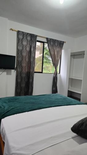 a bedroom with a bed and a window at Palmendros Hosteria in Montañita