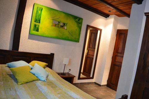 a bedroom with a bed and a painting on the wall at Auberge Aal Veinen in Vianden