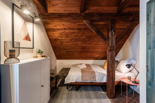 a bedroom with a bed with a wooden ceiling at Chata Alpina Horní Mísečky in Horni Misecky