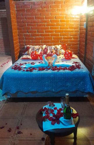 a bed with balloons and a table with wine glasses at Hosteria Kindi Wasi in Puyo