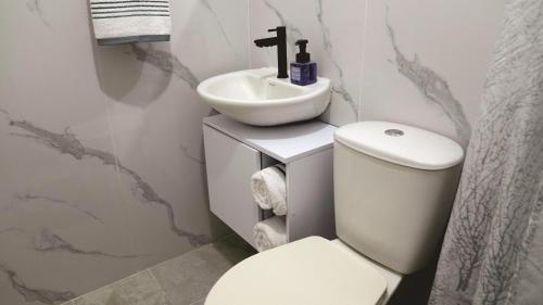 un baño con inodoro y lavabo en Cali te espera, en Cali