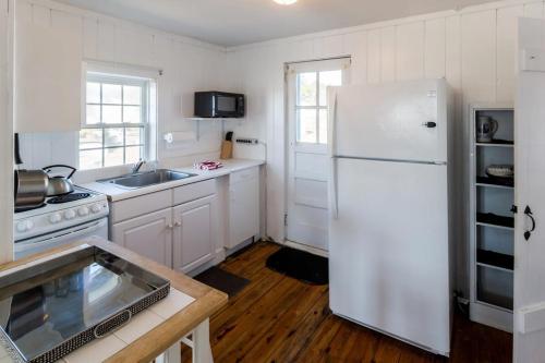 a kitchen with a white refrigerator and a sink at Across from Mayo Beach walk to downtown in Wellfleet