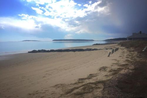 a sandy beach with a view of the ocean at Across from Mayo beach walk to downtown in Wellfleet