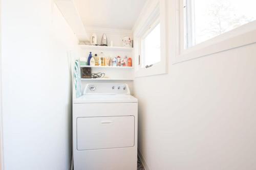 a white laundry room with a washer and dryer at National Seashore w Modern Architecture in Wellfleet
