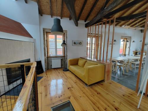 a living room with a yellow couch and a table at Urbe Sanchina - Hostel & Suites in Guarda