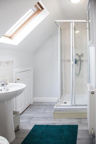 a white bathroom with a shower and a sink at Stylish quaint home hosted by ESONGRACE Stays in Stoke-on-Trent - Perfect for Families - Contractors - Holiday makers - Emergency Housing - Professionals in Stoke on Trent