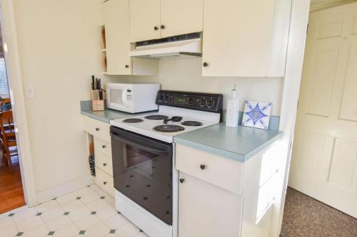 a kitchen with a stove and a microwave at Heart of Brewster 5 Miles to Beach in Brewster