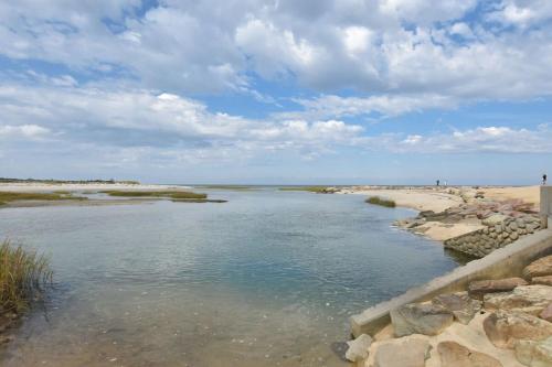 a body of water next to a sandy beach at Heart of Brewster 5 Miles to Beach in Brewster