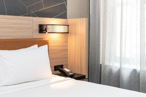 a bedroom with a bed with a phone next to a window at SpringHill Suites by Marriott Baltimore Downtown Convention Center Area in Baltimore