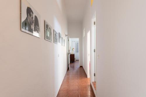 a hallway with white walls and pictures on the walls at Balcony Spacious 2BR Arucas Historic Center in Arucas