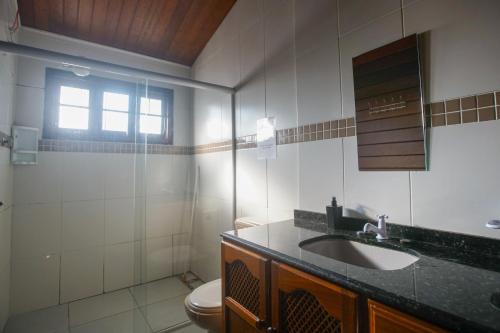 un bagno con lavandino e WC di Hostel Capricórnio Carcará a Caraguatatuba