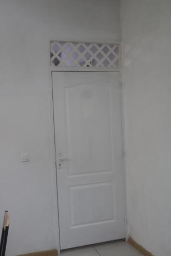 a white closet with a white door in a room at Le Moringa in Baie-Mahault