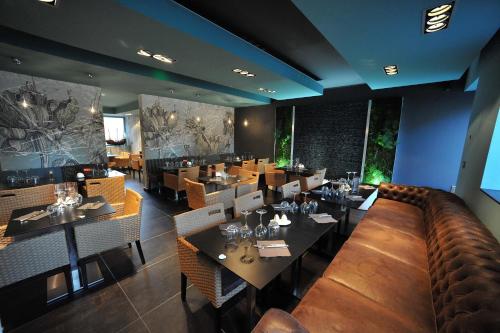 a restaurant with tables and chairs and a bar at Nota Bene in Montceau-les-Mines