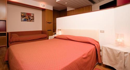 a bedroom with a red bed and a table at Grand Hotel President in Spilimbergo