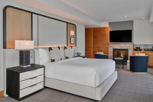 a bedroom with a large white bed and a fireplace at The Ritz-Carlton, Lake Tahoe in Truckee