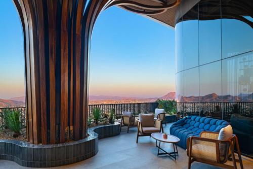 a balcony with a blue couch and chairs on a building at Vetta, Distrito Uno, Autograph Collection in Chihuahua