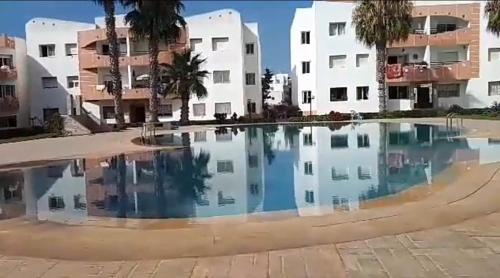 a pool of water in front of a building at superbe appartement Al Mansouria-les jardins de l'Atlantique in Pont Blondin