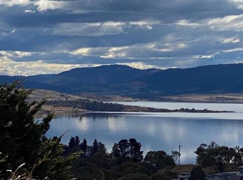 a view of a lake with mountains in the background at Rusty's Ridge in Jindabyne